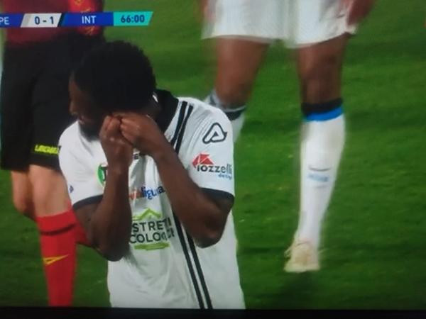 Nzola cố tháo khuyên tai của mình. Ảnh: Football Italia. Nzola cố tháo khuyên tai của mình. Ảnh: Football Italia.