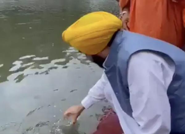 Ông Mann múc nước từ dòng sông mà người dân than phiền là ô nhiễm. Ảnh: Twitter.