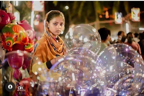 Kisbu đang bán bóng bay. Ảnh: Arjun Krishnan. Kisbu đang bán bóng bay. Ảnh: Arjun Krishnan.