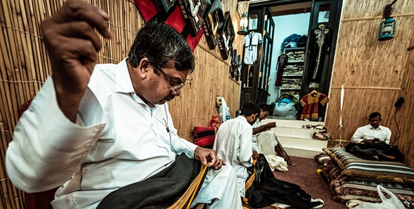 Những người thợ may đang may áo bisht ở Doha (Qatar). Ảnh minh họa: Cebu Pacific Air. Những người thợ may đang may áo bisht ở Doha (Qatar). Ảnh minh họa: Cebu Pacific Air.