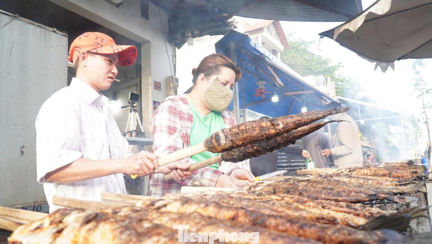 Quán chuẩn bị 2.000 con cá lóc nướng để bán cho khách trong hôm nay. Cá lóc sau khi nướng sẽ được bọc lại bằng giấy bạc để giữ nóng được lâu. Mỗi con cá lóc từ một kg trở lên bán với giá 150.000 đồng.