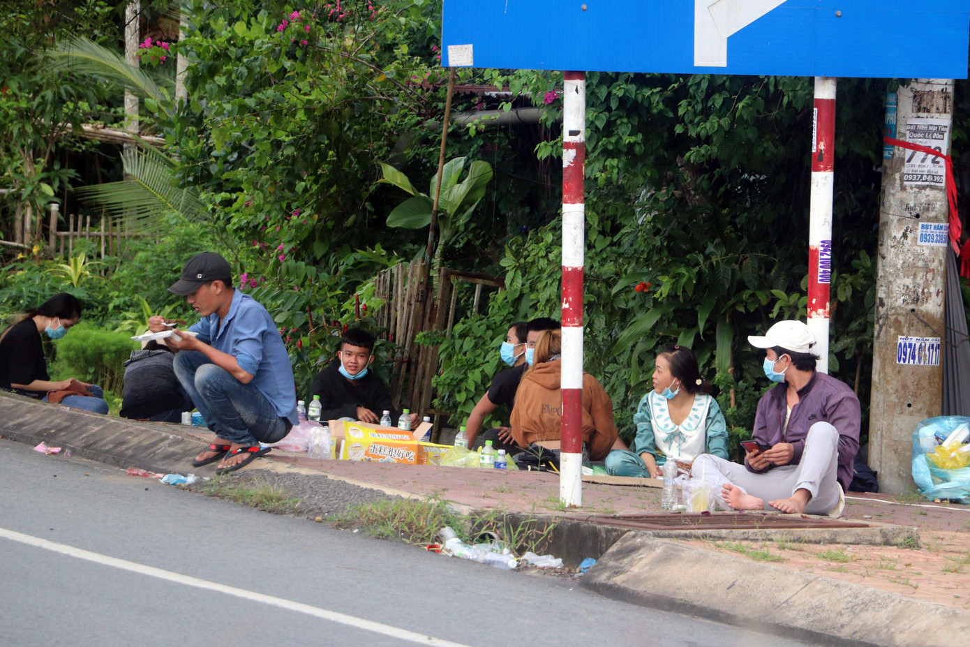 Một lãnh đạo địa phương cho hay, sau khi tỉnh Sóc Trăng chấp thuận tiếp nhận công dân, tỉnh Hậu Giang đã cử lực lượng dẫn đường đưa họ đến giáp ranh Sóc Trăng và bàn giao. Việc này nhằm tạo điều kiện thuận lợi cho bà con, cũng như đảm bảo người dân không dừng đỗ trên địa bàn tỉnh Hậu Giang. Trong ảnh: Người dân chờ đợi để được qua chốt.
