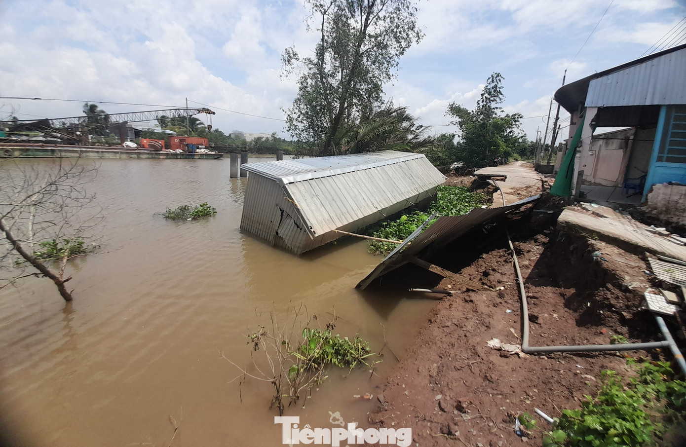 Quán cà phê của chị Mai cùng đoạn đường bê tông bị lôi xuống sông. Ảnh: Cảnh Kỳ.