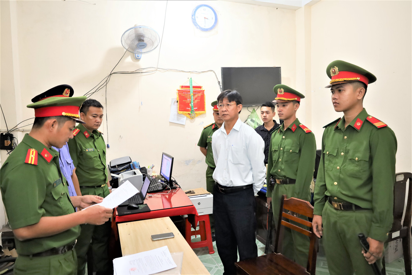 Công an tống đạt quyết định khởi tố bị can đối với Ngô Tấn Quốc (trái) và Phùng Ngọc Ngoan.