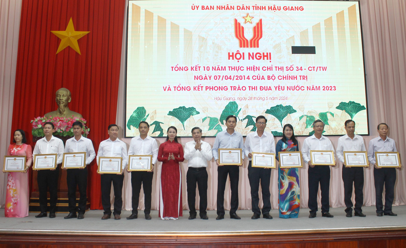 Chủ tịch UBND tỉnh Hậu Giang trao bằng khen cho các đơn vị có thành tích trong thực hiện Chỉ thị 34 của Bộ Chính trị. Ảnh: V.N.