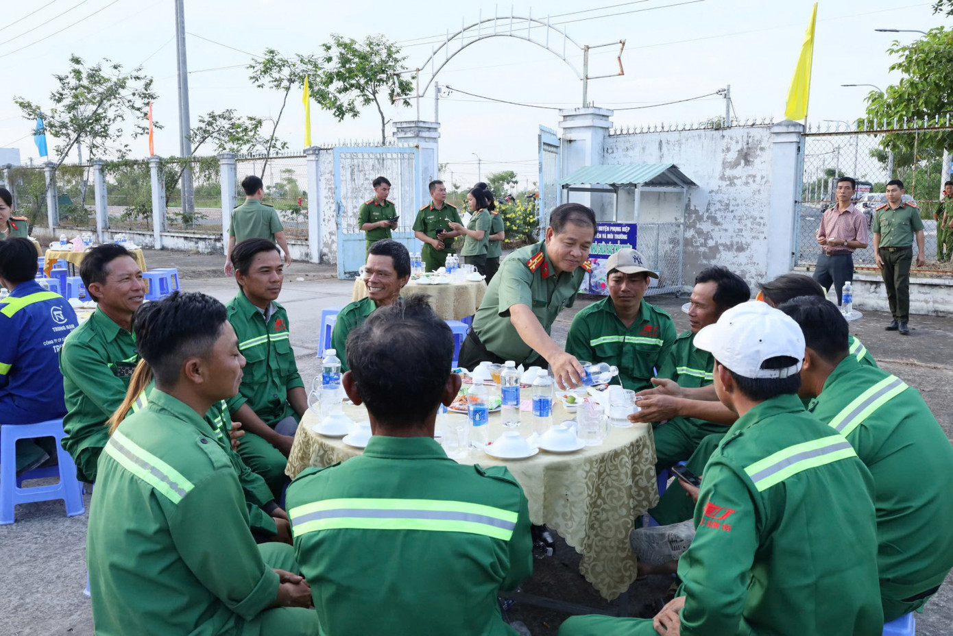 Cán bộ, chiến sĩ công an, chính quyền địa phương dùng cơm thân mật cùng công nhân và bà con nhân dân.