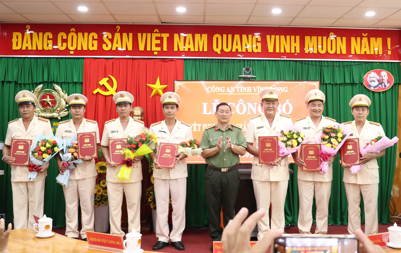 Đại tá Phan Ngọc Tính - Phó Giám đốc Công an tỉnh Vĩnh Long trao quyết định và tặng hoa chúc mừng các cán bộ. Đại tá Phan Ngọc Tính - Phó Giám đốc Công an tỉnh Vĩnh Long trao quyết định và tặng hoa chúc mừng các cán bộ.
