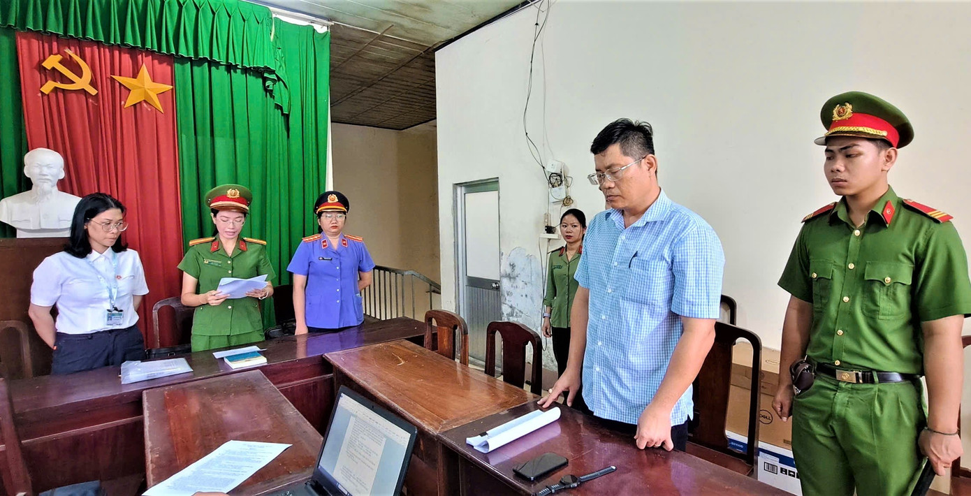 Công an tống đạt quyết định khởi tố bị can đối với Ngô Tấn Quốc (trái) và Phùng Ngọc Ngoan.