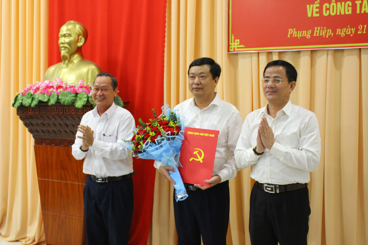 Ông Trần Văn Huyến - Phó Bí thư Thường trực Tỉnh ủy, Chủ tịch HĐND tỉnh (phải) và ông Nguyễn Văn Vui (trái) - Bí thư Huyện ủy Phụng Hiệp trao quyết định và tặng hoa chúc mừng ông Trương Minh Kiêm.