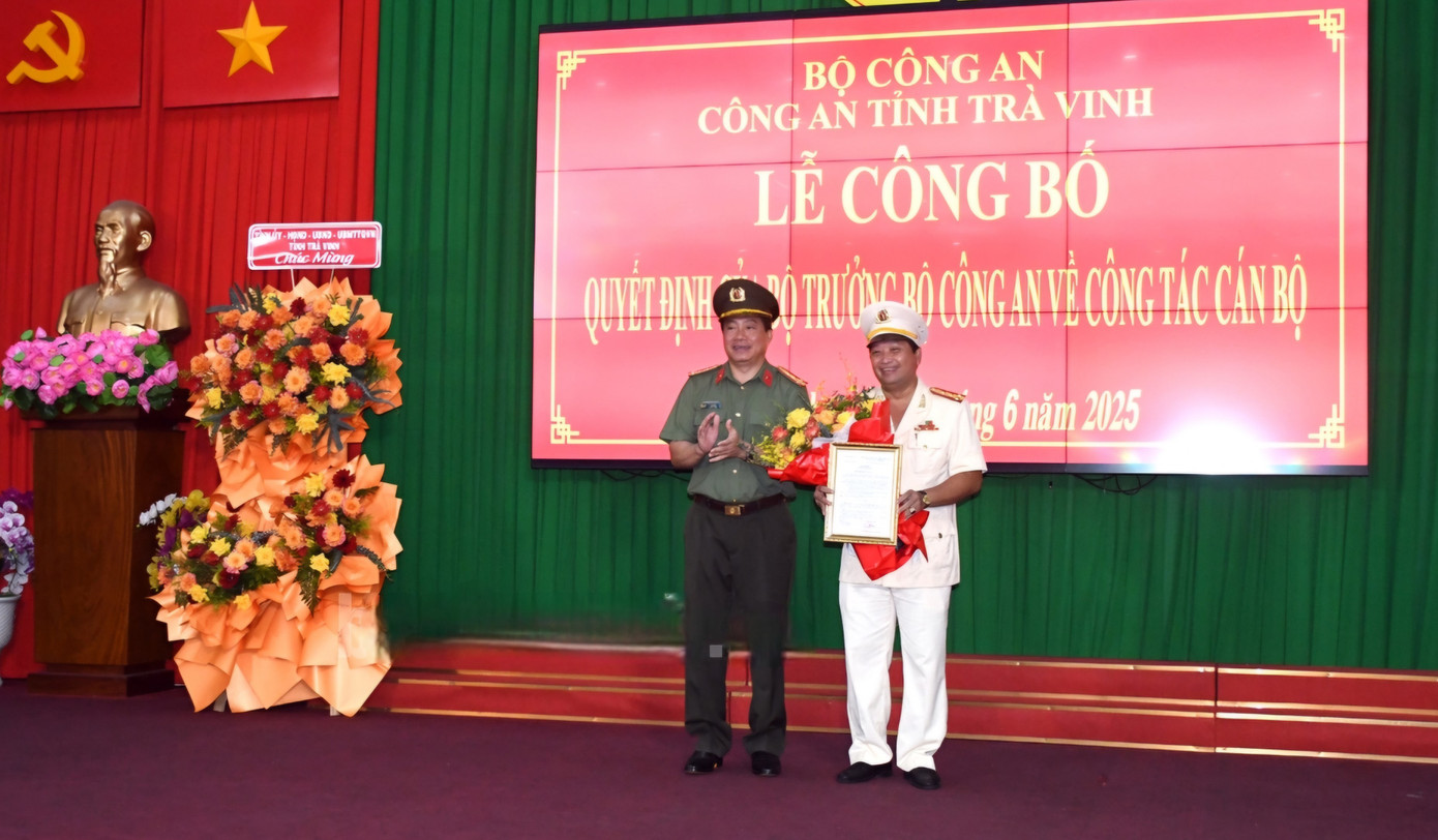 Đại tá Nguyễn Thanh Hải - Giám đốc Công an tỉnh Trà Vinh trao quyết định cho Đại tá Trần Quốc Phục (phải). Ảnh: Phạm Hơn