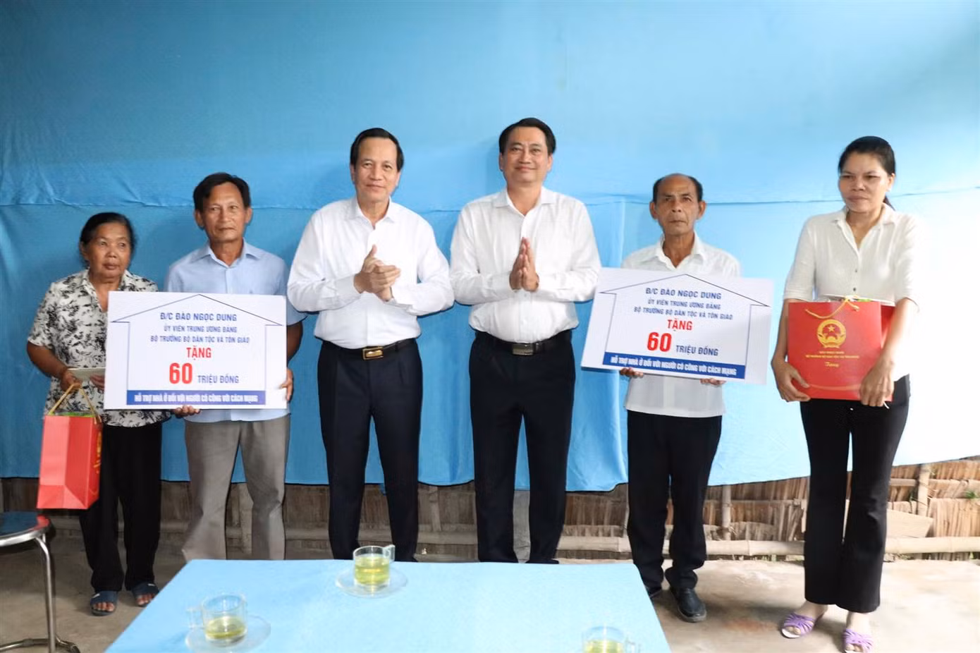 Bộ trưởng Đào Ngọc Dung cùng Phó Chủ tịch UBND tỉnh Trà Vinh - Nguyễn Quỳnh Thiện trao bảng tượng trưng tặng nhà tình nghĩa cho các hộ gia đình chính sách người dân tộc Khmer. Ảnh: Quốc Bình