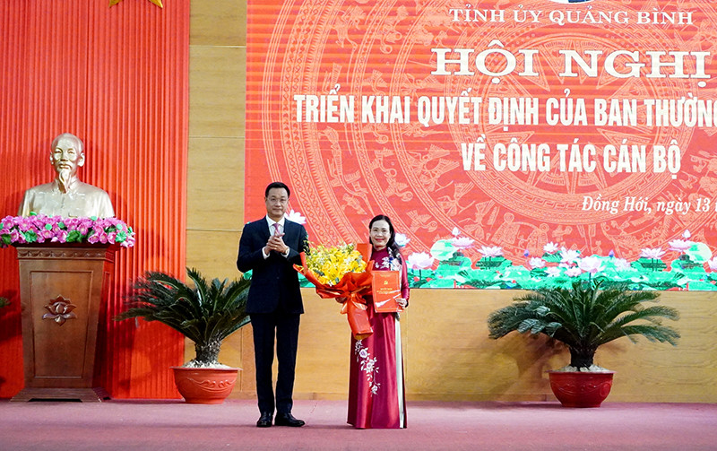 Bí thư Tỉnh uỷ Quảng Bình trao quyết định và tặng hoa chúc mừng bà Phạm Thị Hân.