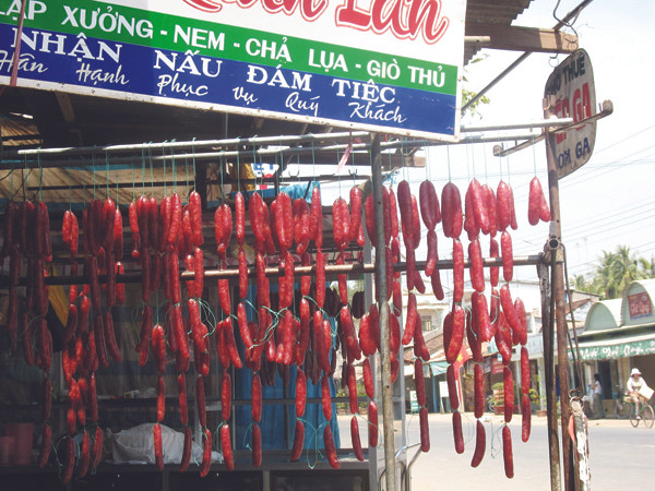 Lạp xưởng hứng bụi, phơi nắng ven đường Ảnh: L.N