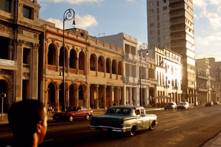 Một chiếc xe hơn 50 năm tuổi lăn bánh giữa hoàng hôn tại Havana