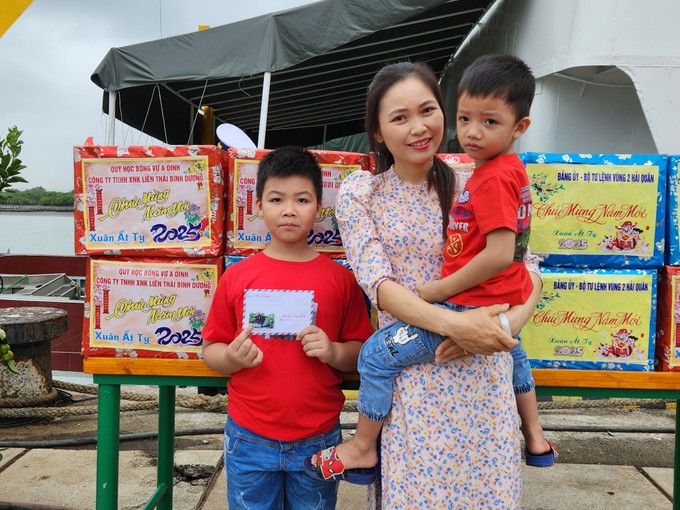 Chị Dương Thị Hương cùng hai con gửi lá thư cùng những lời chúc Tết tốt đẹp đến người chồng, người cha là anh Đào Văn Điệp, nhân viên thông tin đang công tác tại nhà giàn DK1/16. Ảnh: Văn Tuấn