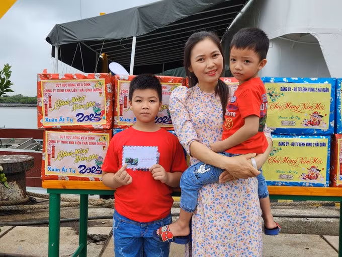 Chị Dương Thị Hương cùng hai con gửi lá thư cùng những lời chúc Tết tốt đẹp đến người chồng, người cha là anh Đào Văn Điệp, nhân viên thông tin đang công tác tại nhà giàn DK1/16. Ảnh: Văn Tuấn