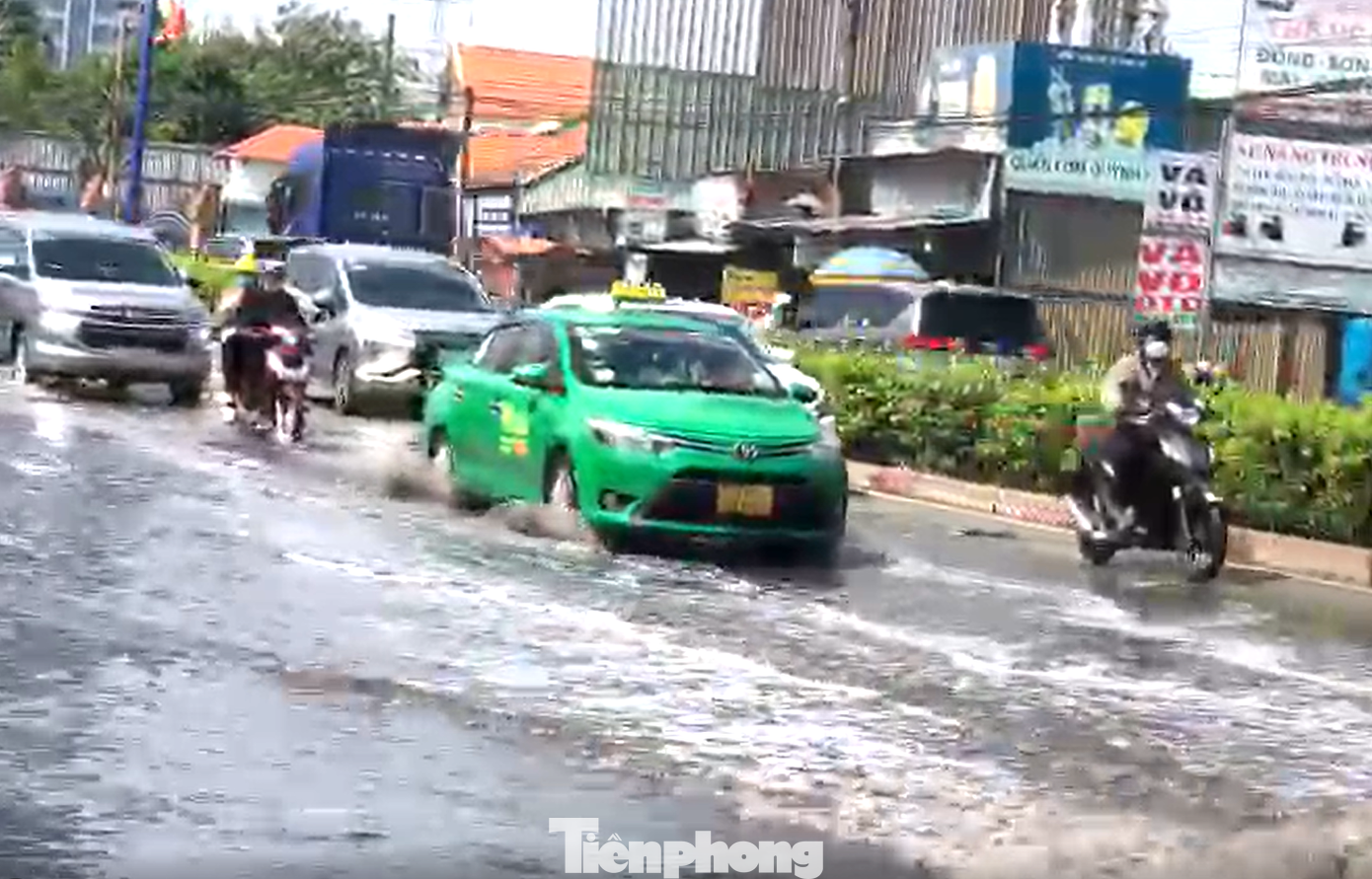 Quốc lộ 13 ngập nước, các phương tiện dồn về cùng một làn sát dải phân cách Quốc lộ 13 ngập nước, các phương tiện dồn về cùng một làn sát dải phân cách