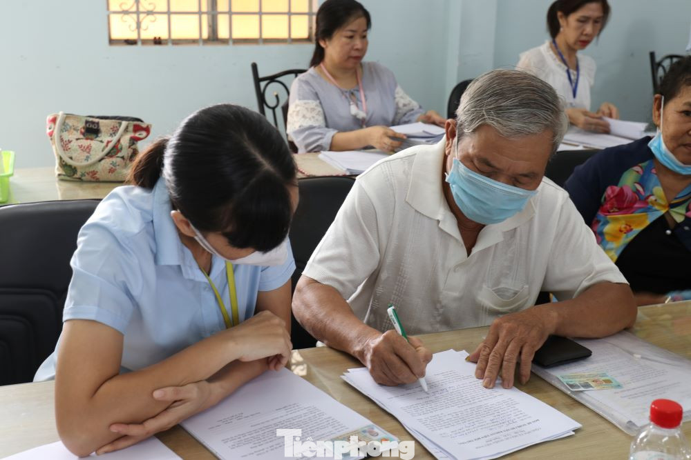 Người dân được cán bộ hướng dẫn làm thủ tục nhận tiền bồi thường Người dân được cán bộ hướng dẫn làm thủ tục nhận tiền bồi thường