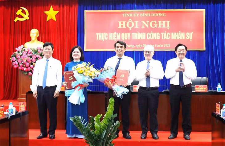 Ông Bùi Thanh Nhân (giữa) và bà Nguyễn Thị Mỹ Hằng (thứ hai từ trái sang) nhận quyết định
