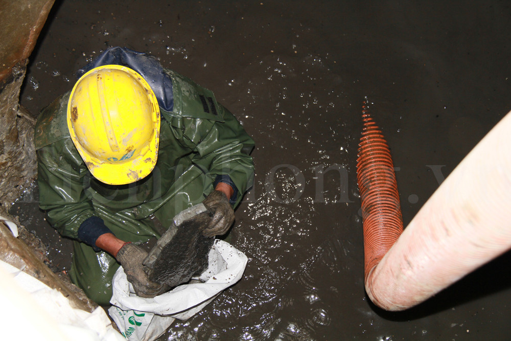 Sau đó, anh Tuấn dùng xà beng đập nhỏ các tảng bê tông này, cho vào bao tải, buộc kín lại, xếp thành đống, chờ tải lên. Ảnh: Trường Phong