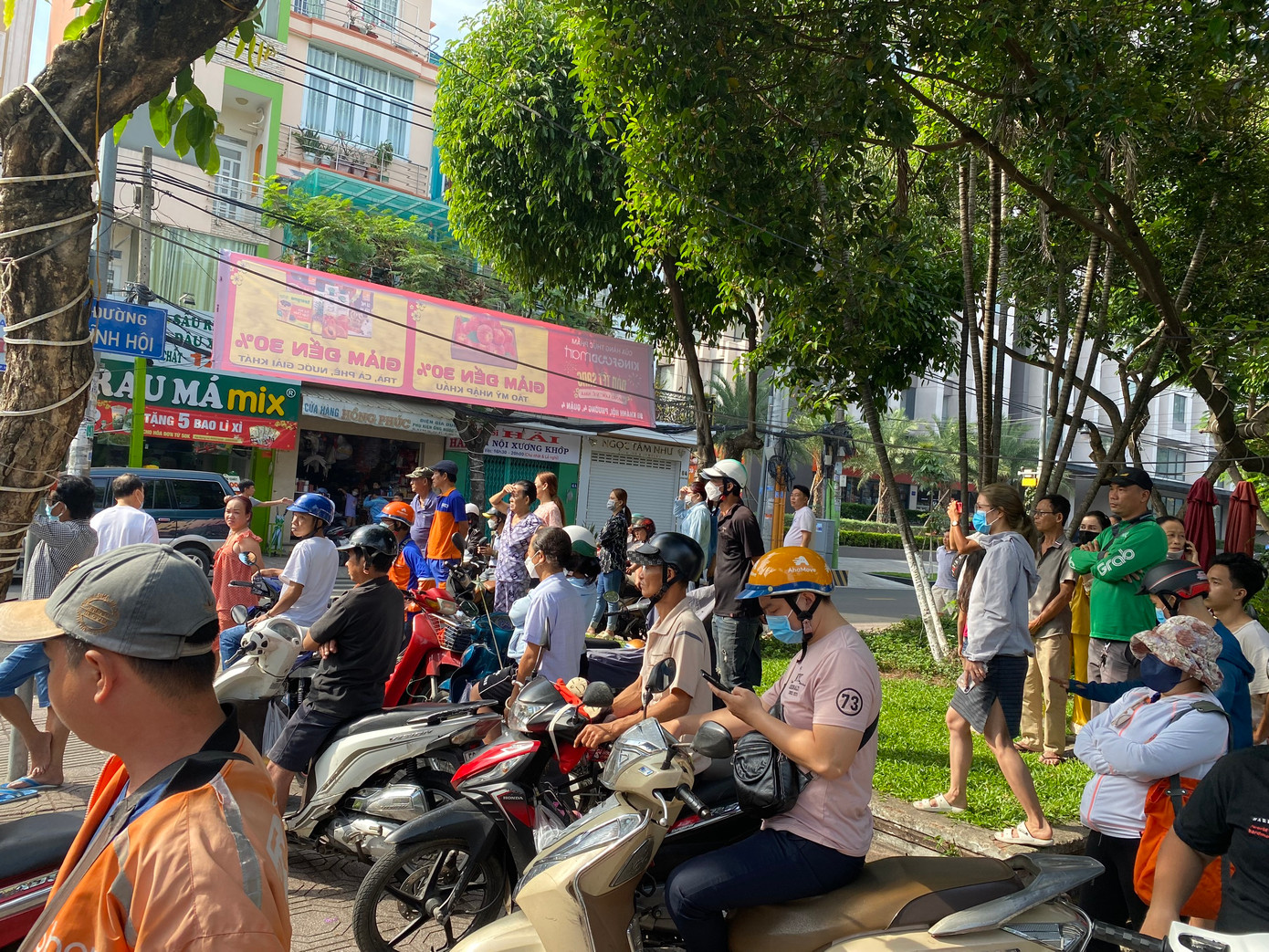 Ông Châu Văn Non (58 tuổi, nhân viên giữ xe ở gần hiện trường vụ việc) cho biết, thời điểm xảy ra vụ việc là khoảng 8h45 sáng. "Lúc đó nghe tiếng "ầm" rất lớn, tôi nhìn thấy nhiều người từ trong cửa hàng chạy ra ngoài thoát thân, cả khu vực toàn là khói bụi". Ảnh: Người dân tập trung theo dõi vụ việc.