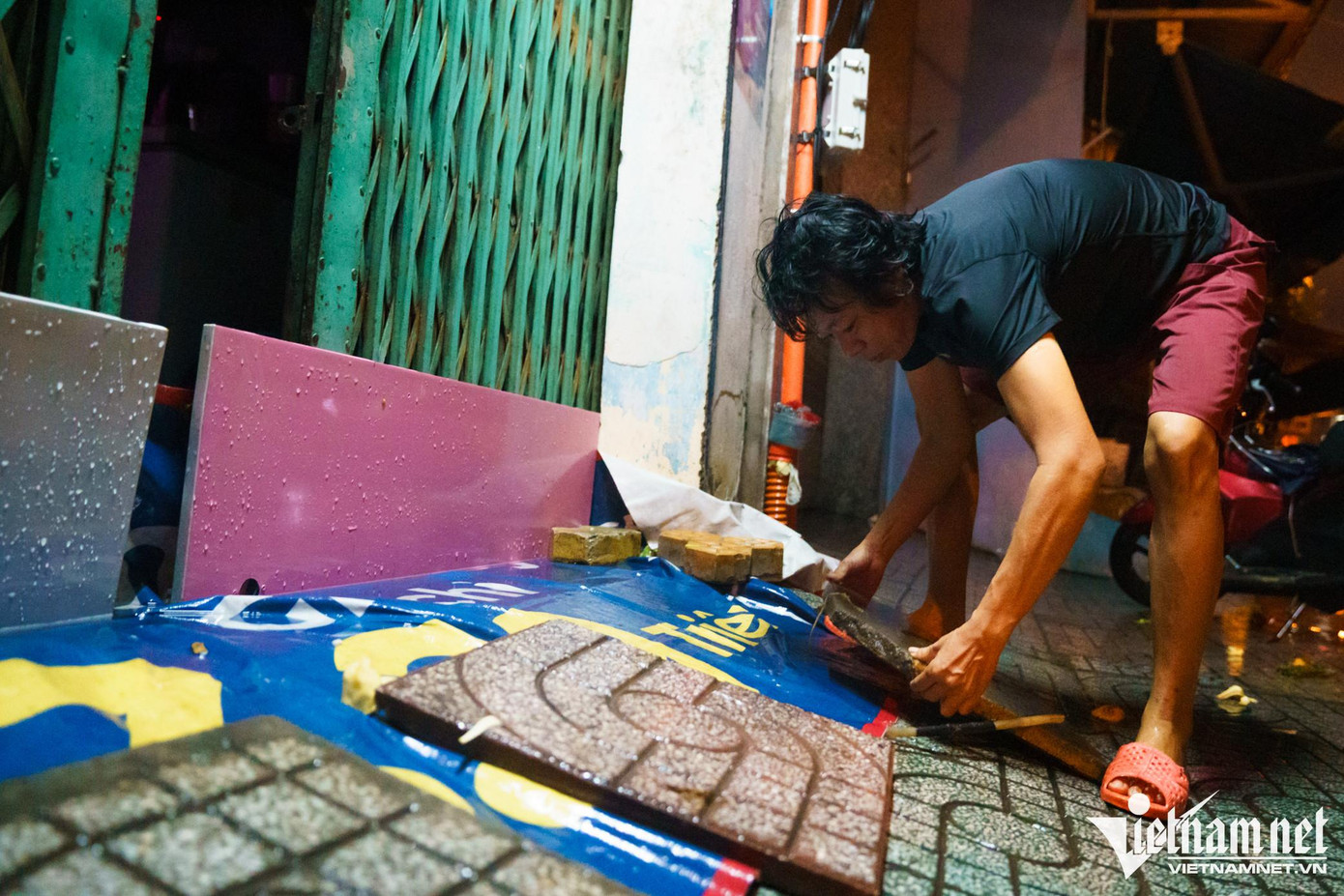 Chị Mai Loan (50 tuổi) thức từ 2h30 để chuẩn bị gạch và vách gỗ chặn nước tràn vào nhà. "Cứ mỗi tháng đỉnh triều cường xuất hiện 2 lần vào đầu và giữa tháng, nhưng trước và sau 3 ngày đỉnh triều, nhà chị đều phải chịu cảnh ngập nước lênh láng", chị Loan kể.