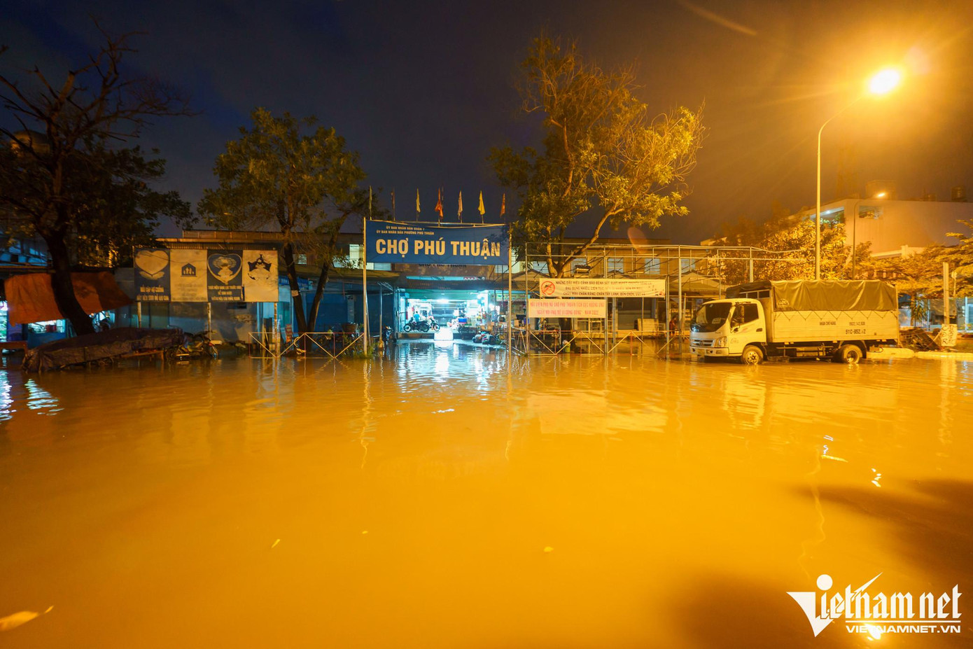 Trên đường Cao Thị Chính (quận 7), phía trước khu vực chợ Phú Thuận, nước bủa vây 4 mặt chợ. Nhiều tiểu thương phải thay đổi thời gian mở cửa hàng vì khi ngập không có khách đến.