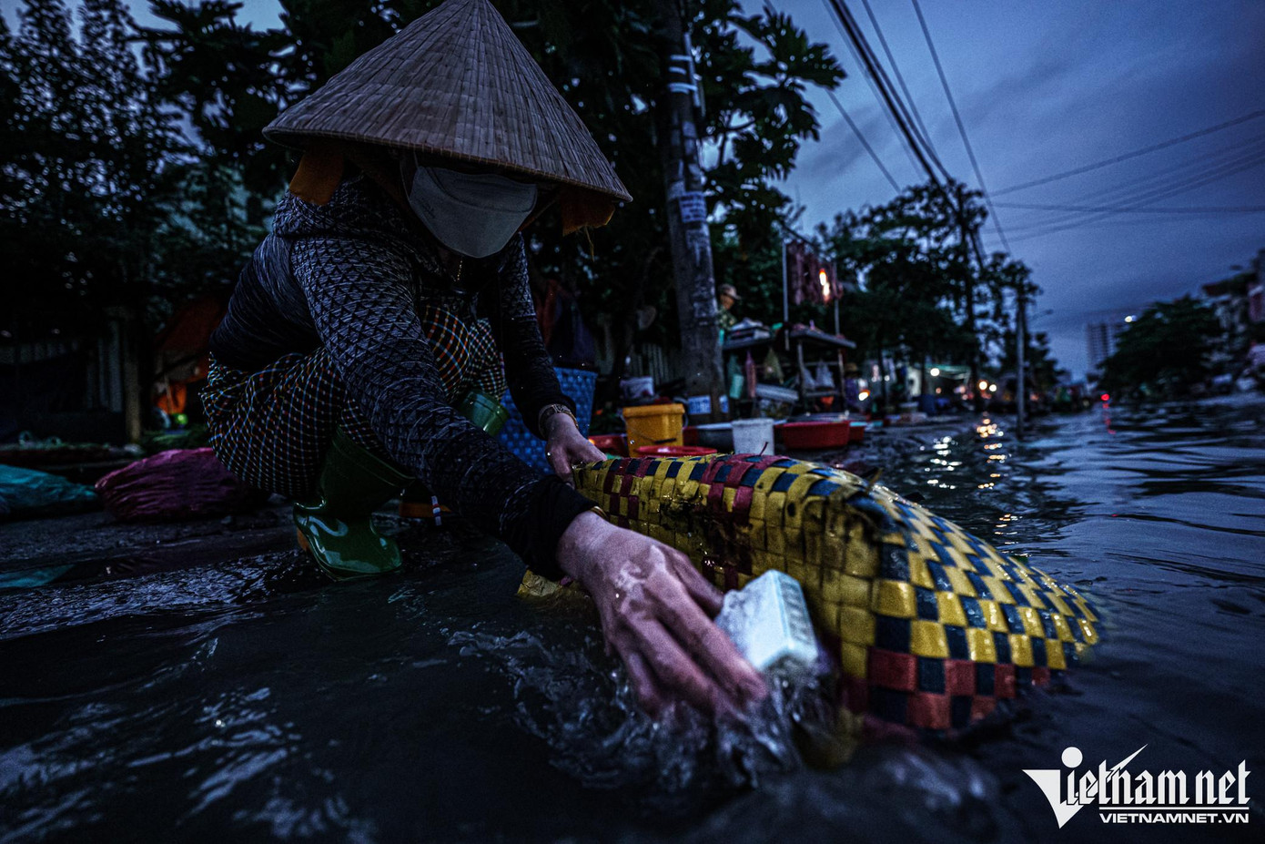 Chị Nguyễn Thị Mỹ Lệ (37 tuổi, tiểu thương bán cá ở chợ) đang tranh thủ chà giỏ đựng đồ nghề bán cá bằng nước thủy triều, sau đó rửa lại một lần bằng nước sạch, để tiết kiệm nước.