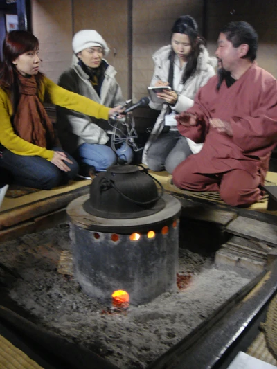 Du khách trẻ trò chuyện bên bếp củi nhà ông Oizumi