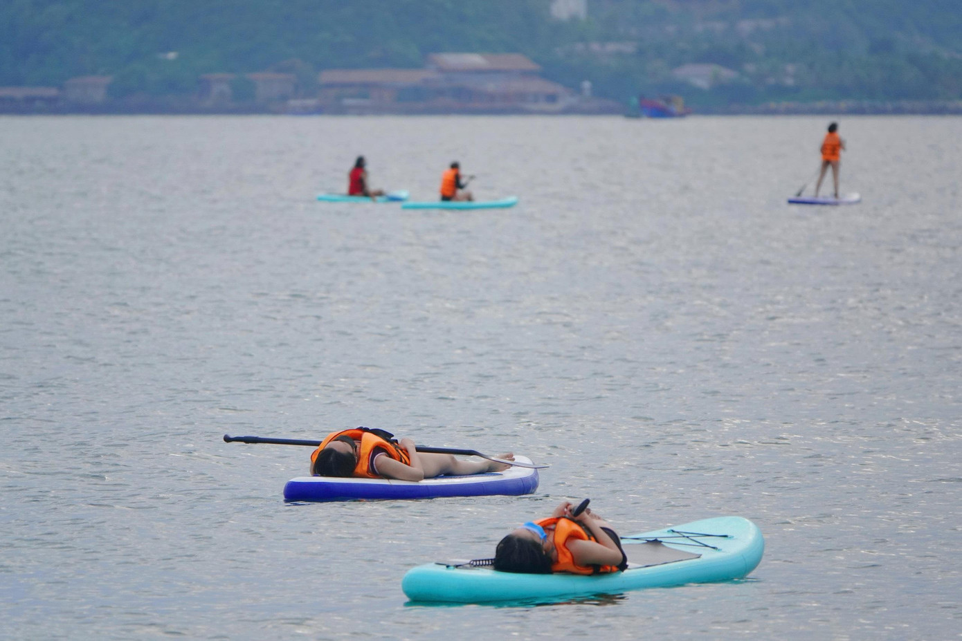 Du khách nằm thư giãn trên SUP để trải nghiệm cảm giác thư thái giữa biển.