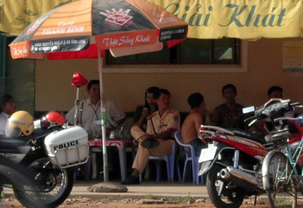 Cảnh sát giao thông ngồi trong quán cà phê, vắt chân khi làm nhiệm vụ. Ảnh: A.N. Cảnh sát giao thông ngồi trong quán cà phê, vắt chân khi làm nhiệm vụ. Ảnh: A.N