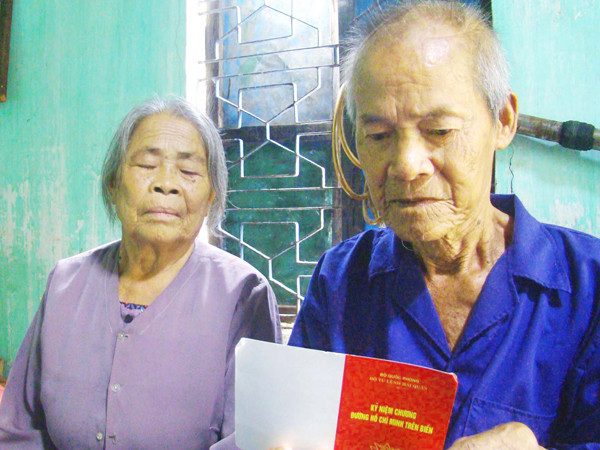 Ông Trần Lứ và vợ với Kỷ niệm chương đường HCM trên biển Ảnh: L.V.C 