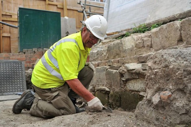 Một nhà khảo cổ đang làm việc tại hiện trường khai quật, nơi hơn 300 ngôi mộ cổ được phát hiện - Ảnh: COTSWOLD ARCHAEOLOGY