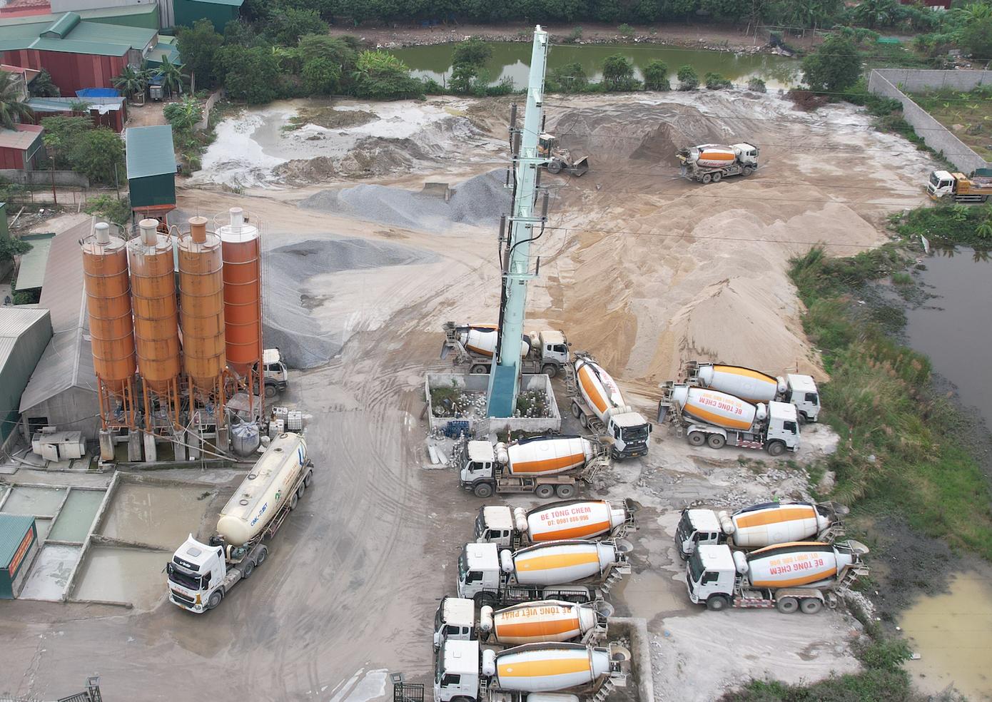 Trạm trộn bê tông vẫn hoạt động rầm rộ với hàng chục xe bê tông Chèm vây quanh.
