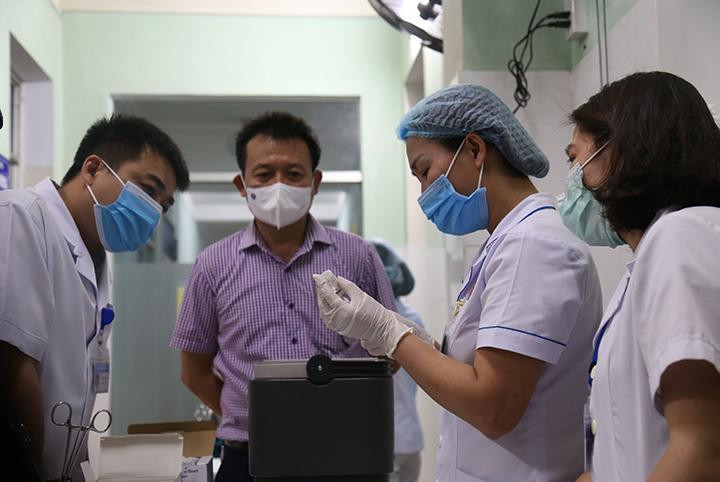 Cán bộ y tế kiểm tra vắc xin COVID - 19 trước khi tiêm