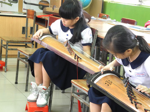 Mỗi em được kê chân cao trên ghế để đánh đàn. Mỗi em được kê chân cao trên ghế để đánh đàn