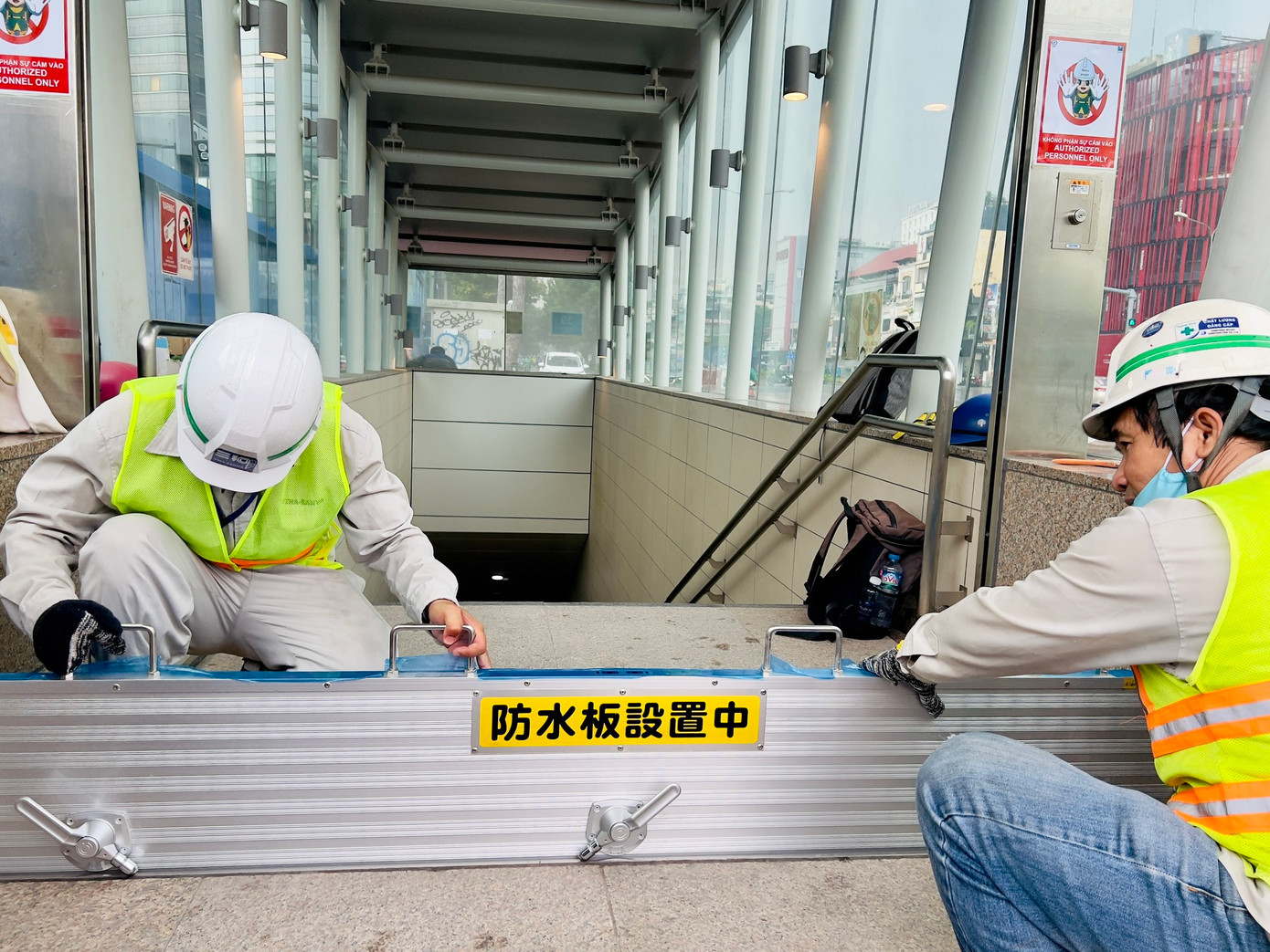 Nhà thầu thi công ga ngầm tuyến metro số 1 (tuyến Bến Thành - Suối Tiên) trình diễn quy trình lắp đặt cửa ngăn nước tại các cửa vào nhà ga ngầm. Ảnh: MAUR