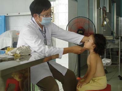 Bác sĩ đang khám cho cháu Ngân - người bị bảo mẫu hành hạ khi tắm. Ảnh: Song Nguyên.