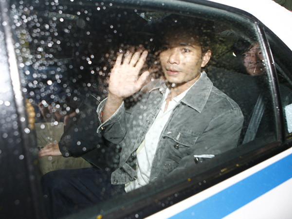 Anh Hùng giơ tay chào tạm biệt các phóng viên khi bước lên taxi