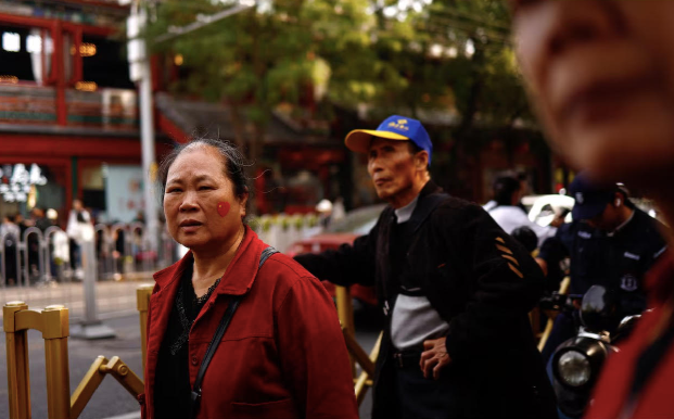 Một phụ nữ ở Bắc Kinh dán hình quốc kỳ lên má. (Ảnh: Reuters) Một phụ nữ ở Bắc Kinh dán hình quốc kỳ lên má. (Ảnh: Reuters)