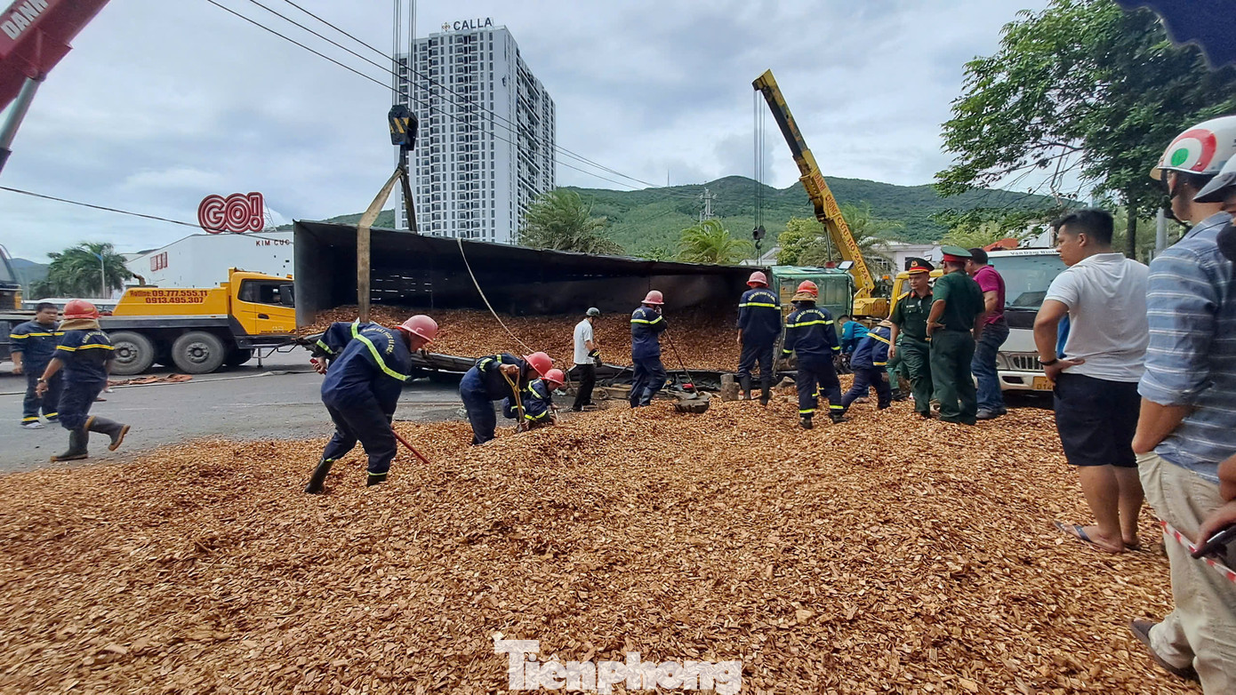 Lực lượng cứu hộ xúc lớp dăm gỗ lên kiểm tra xem còn nạn nhân nào bị vùi phía dưới không. Ảnh: Trương Định