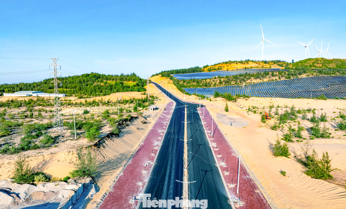 Tuyến đường xuyên qua đồi cát, bên cạnh những "cánh đồng" điện mặt trời, cột điện gió. Ảnh: Dũng Nhân.