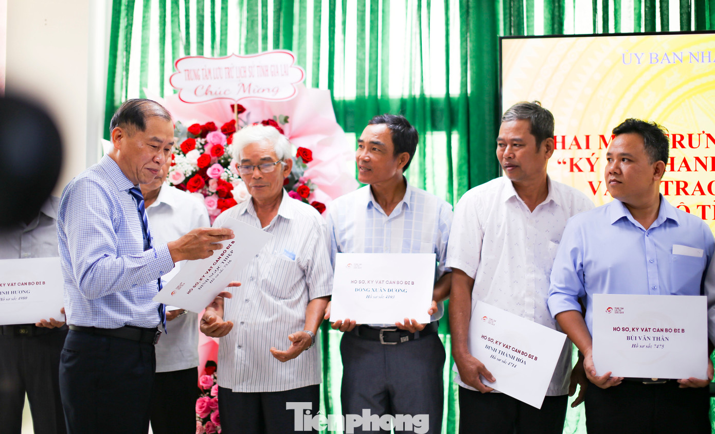 Ông Lê Minh Tuấn - Giám đốc Sở Nội vụ tỉnh Bình Định (bên trái) - trao lại hồ sơ, kỷ vật cán bộ tỉnh Bình Định đi B cho người thân các gia đình. Ảnh: Trương Định.