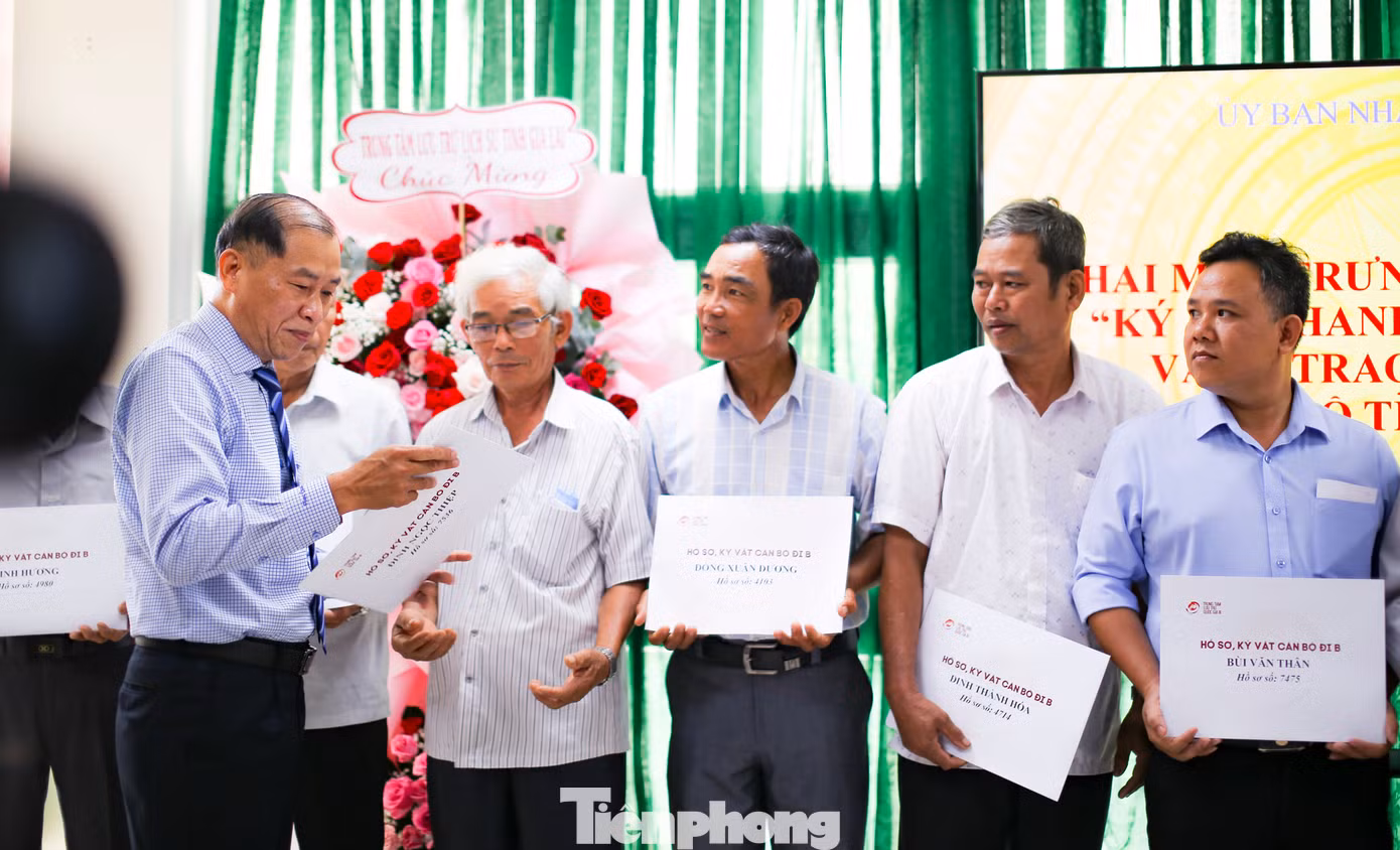 Ông Lê Minh Tuấn - Giám đốc Sở Nội vụ tỉnh Bình Định (bên trái) - trao lại hồ sơ, kỷ vật cán bộ tỉnh Bình Định đi B cho người thân các gia đình. Ảnh: Trương Định.