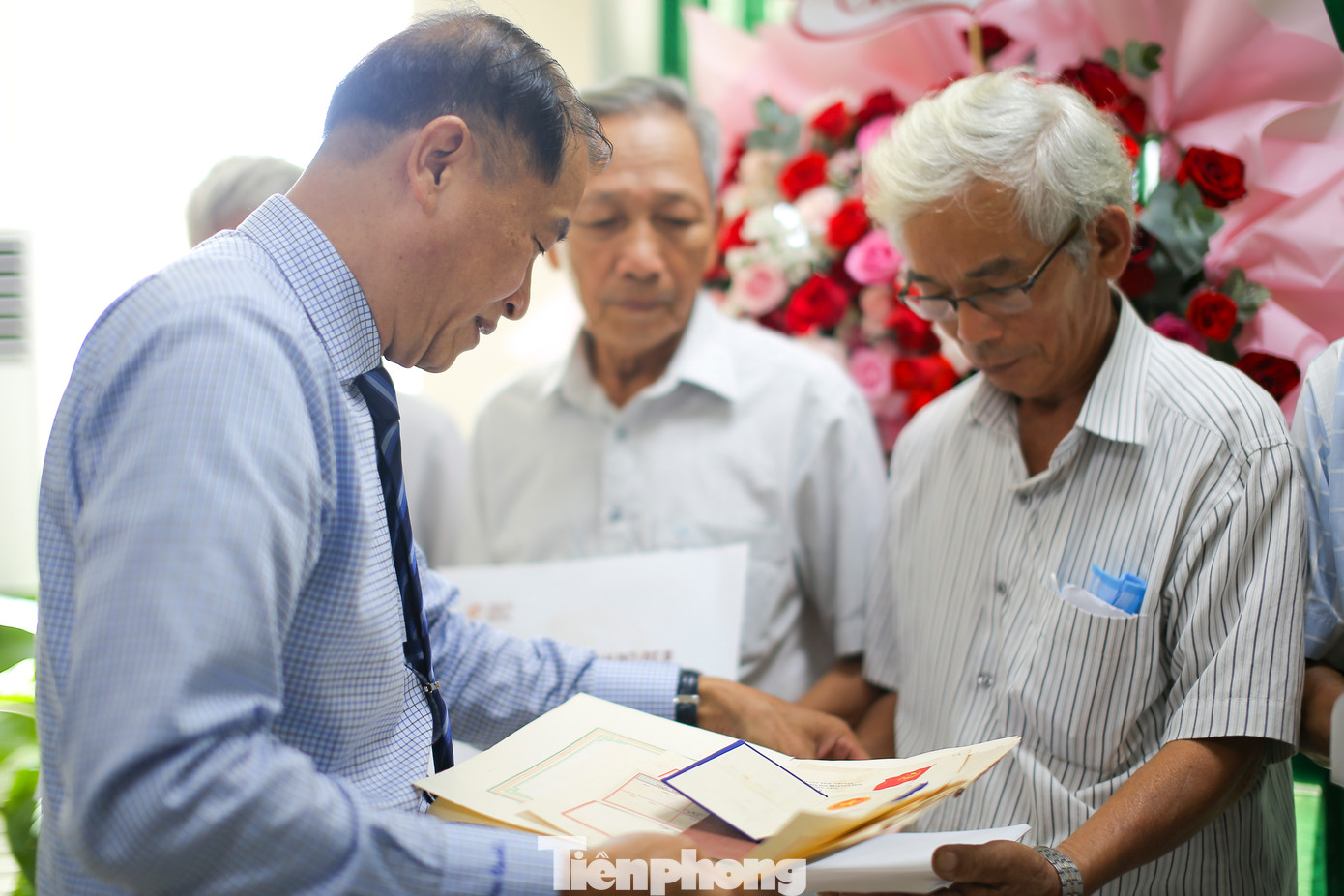 Ông Lê Minh Tuấn - Giám đốc Sở Nội vụ tỉnh Bình Định (bên trái) - trao lại hồ sơ, kỷ vật cán bộ tỉnh Bình Định đi B cho người thân các gia đình. Ảnh: Trương Định.