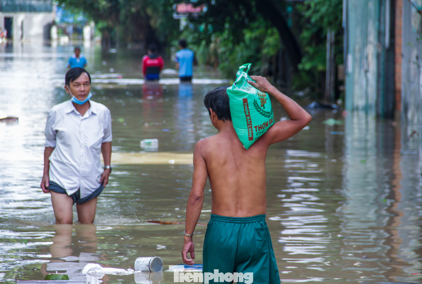 Một điểm vẫn còn bị ngập sâu trong biển nước tại phường Nhơn Phú sáng 12/10. Người dân cõng gạo vào cho người thân. Ảnh: Trương Định Một điểm vẫn còn bị ngập sâu trong biển nước tại phường Nhơn Phú sáng 12/10. Người dân cõng gạo vào cho người thân. Ảnh: Trương Định
