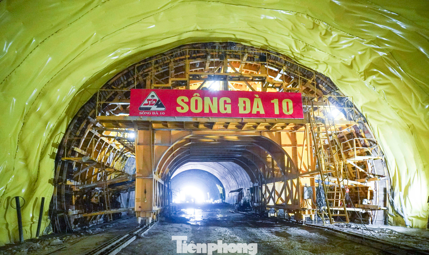 Ông Nguyễn Văn Quảng - Giám đốc Điều hành nhà thầu Sông Đà 10, cho biết, công việc tại ống hầm bên trái hầm Sơn Triệu đã đạt 60% tiến độ. Đơn vị gặp khó khăn bởi địa chất lòng núi ở đây cực kỳ phức tạp. Đất đá trong lòng núi dạng bở, nhiều mạch nước ngầm lớn nên rất dễ xảy ra sụt vỡ. Phương pháp thi công là đào hầm khẩu độ ngắn, đào đến đâu thì gia cố mái vòm phun bê tông chắc chắn đến đó. Ảnh: T.Đ