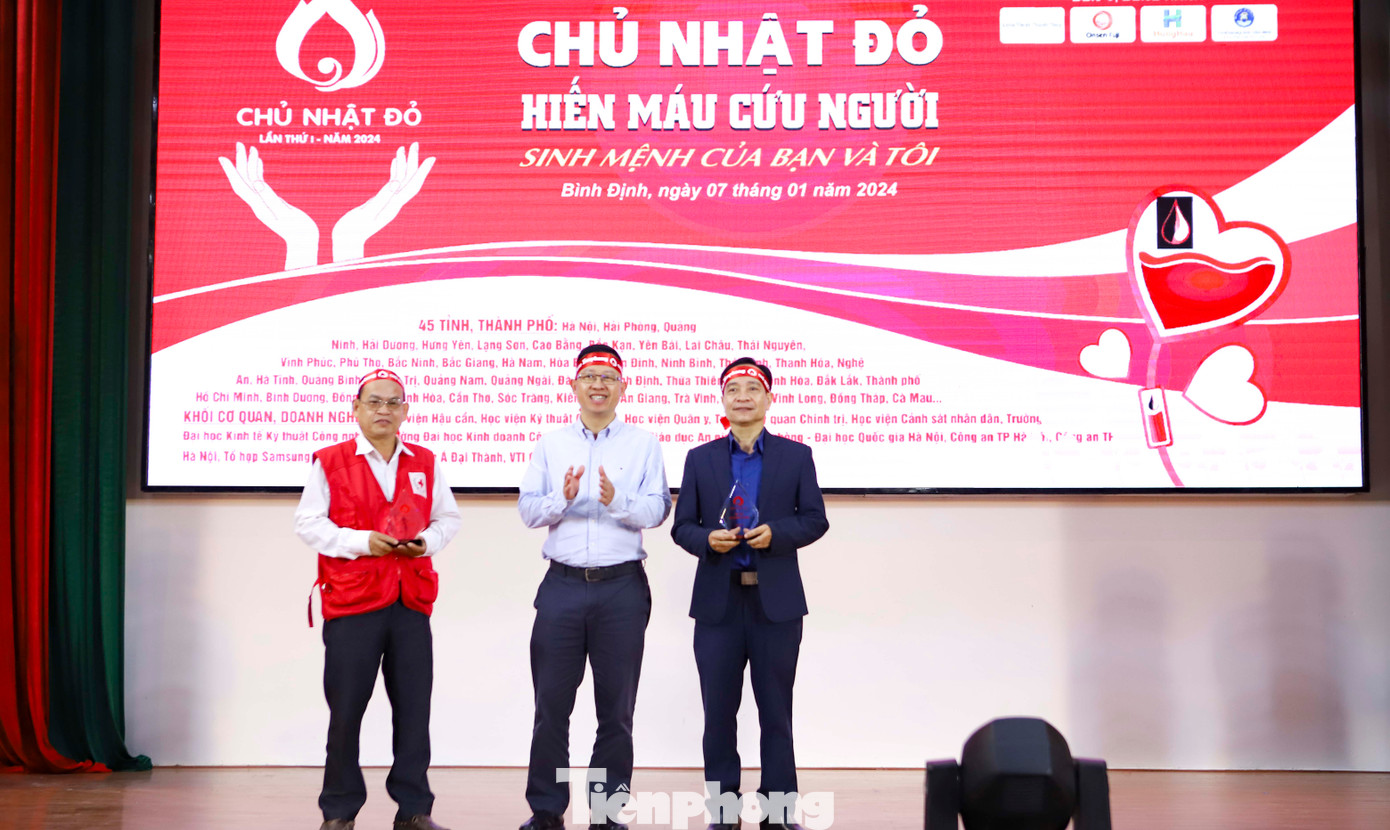 Nhà báo Lê Minh Tuấn - báo Tiền Phong (ở giữa) trao kỷ niệm chương cho đơn vị phối hợp chương trình Chủ Nhật Đỏ tỉnh Bình Định lần thứ I – năm 2024. Ảnh: Trương Định