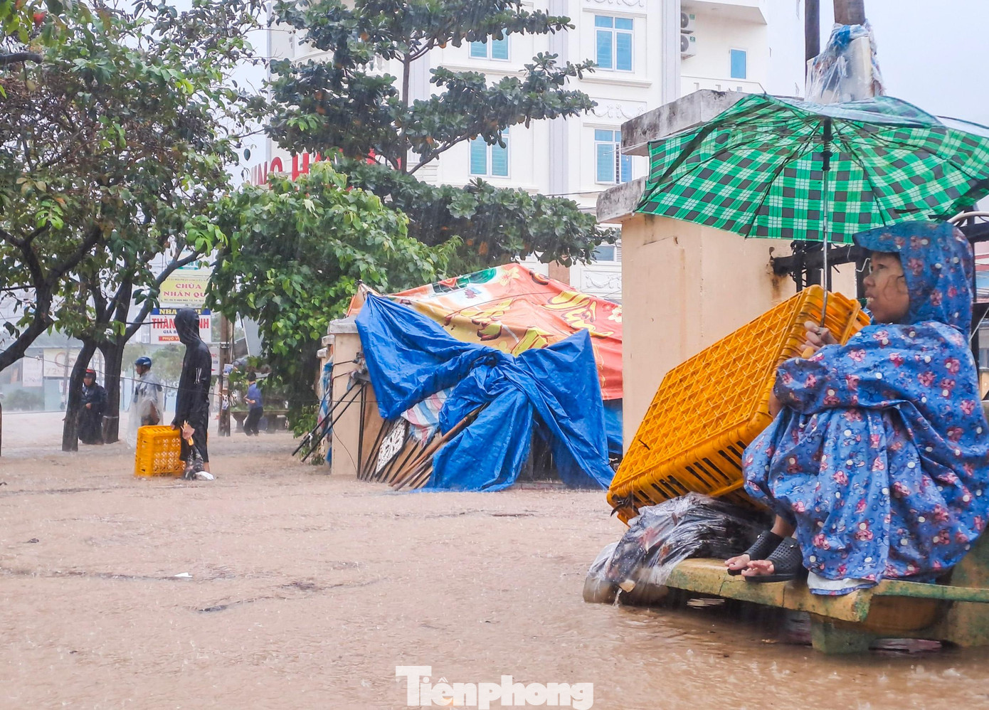 Người dân không về được nhà phải chờ người thân đến hỗ trợ. Ảnh: Trương Định
