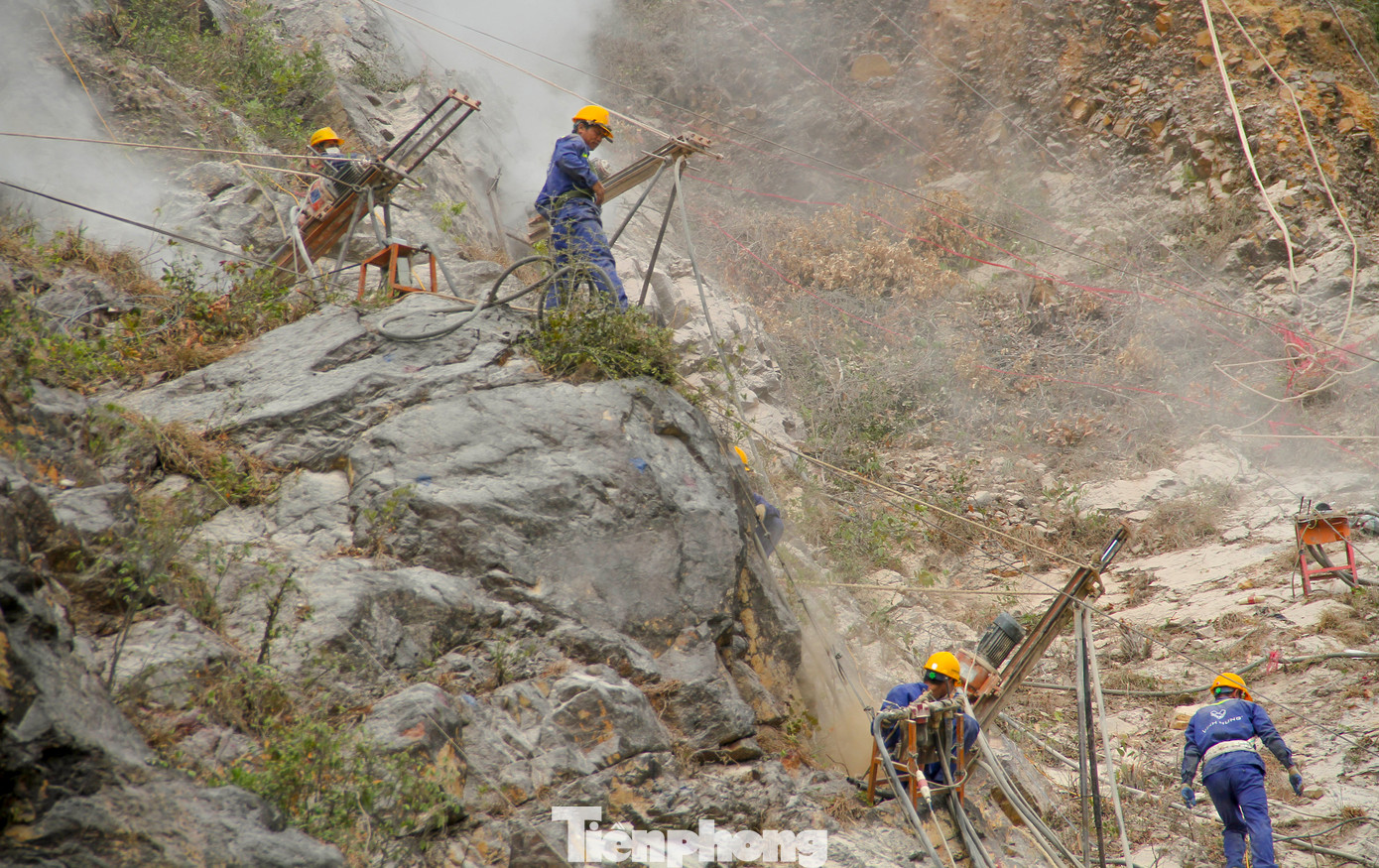 Công nhân tiến hành khoan vào vách núi để nhằm khắc phục tình trạng sạt lở theo đồ án. (Ảnh: Trương Định)